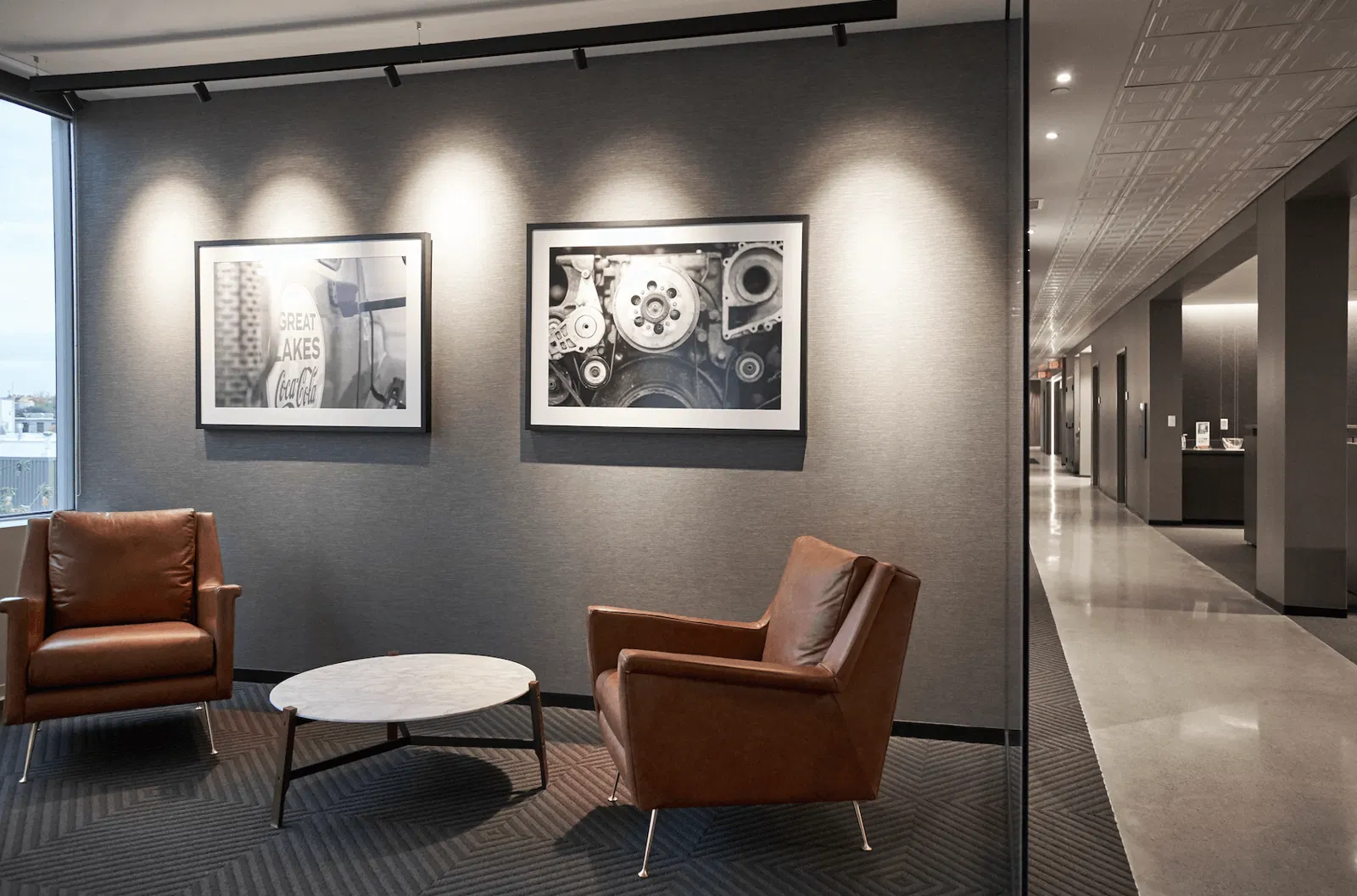 Rest zone: dark-cream leather chairs at the gray hallway
