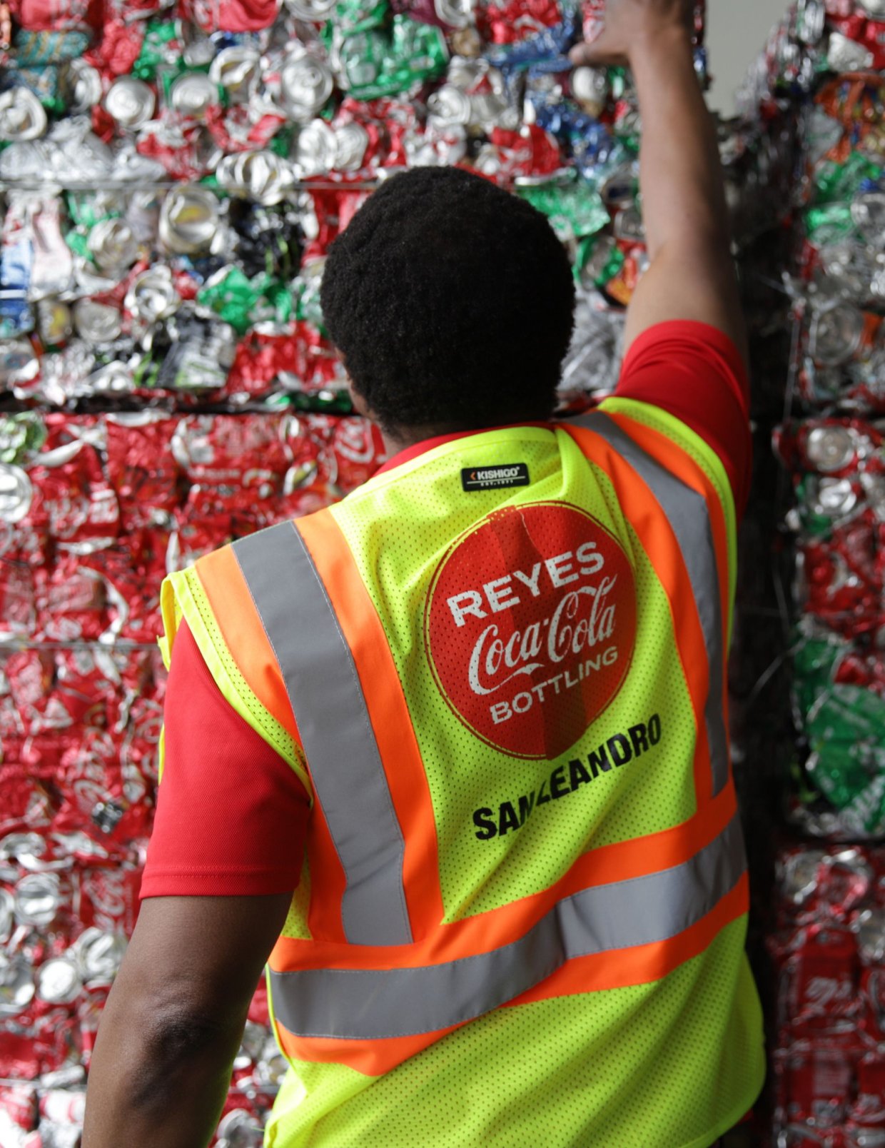 The man is doing something with crushed recyclable cans