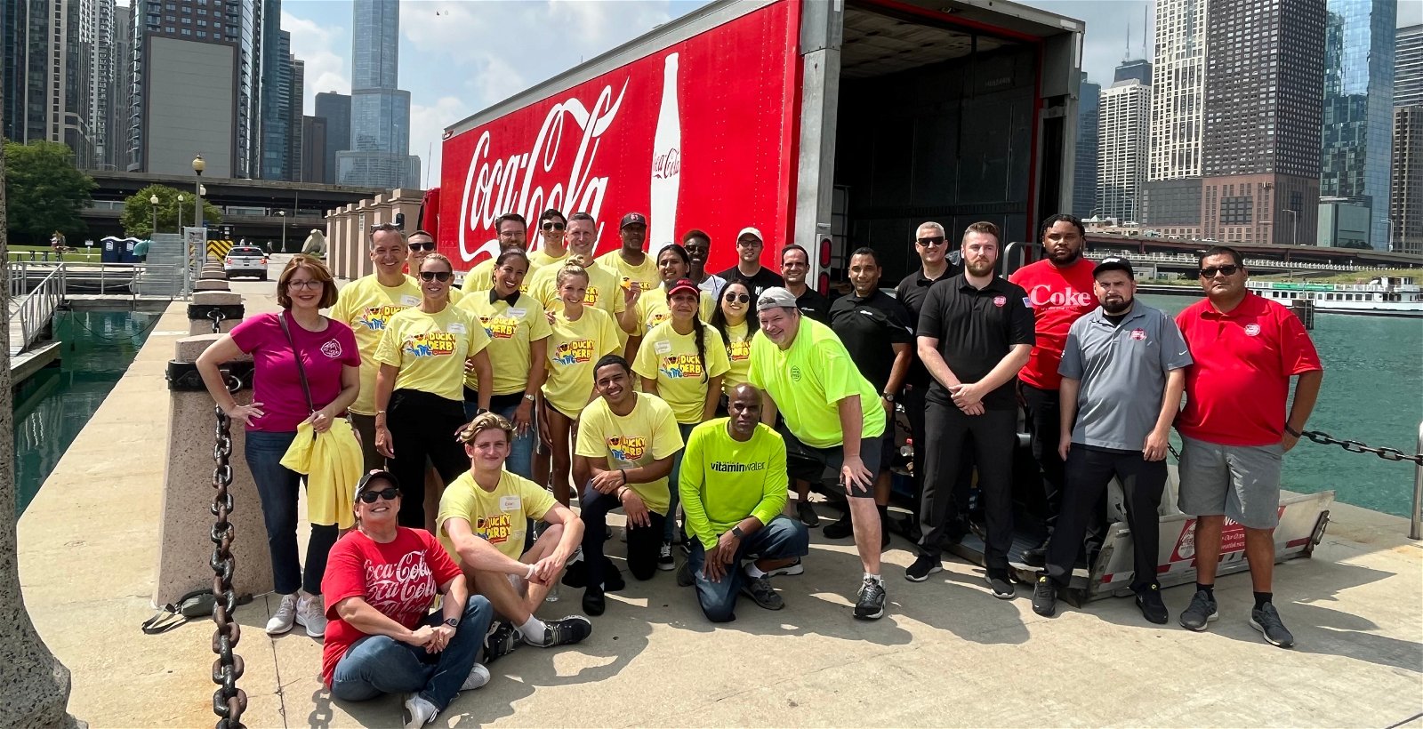Large group of employees in front of a Coca-Cola truck